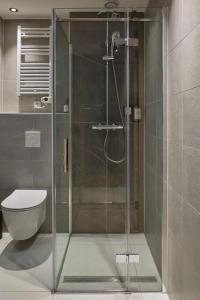 a glass shower in a bathroom with a toilet at Breathe Hotel Leiden in Leiden