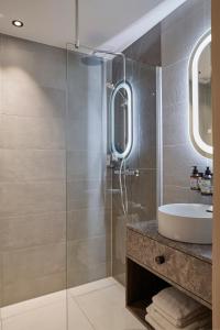 uma casa de banho com um lavatório e um chuveiro em Breathe Hotel Leiden em Leiden