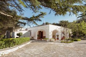 an exterior view of a white building with a courtyard at I trulli di Kate in Monopoli