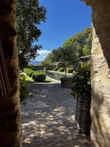 - une vue sur le jardin depuis une arche en pierre dans l'établissement Le Mas de Béthel, à Gordes
