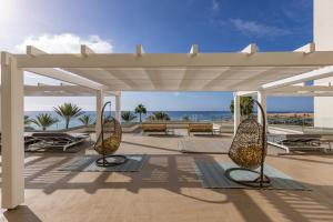 a pavilion with twoulptures on a patio with the ocean at Corallium Dunamar by Lopesan Hotels - Adults Only in Playa del Ingles