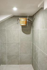 uma casa de banho com um chuveiro e uma cesta na parede em Astrea Deluxe em Hisarja