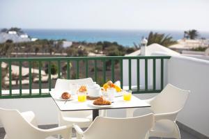 a table with a plate of food on a balcony at Apartamentos El Guarapo in Costa Teguise