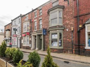 a row of brick buildings on a street with christmas trees at 10 Chaloner in Guisborough