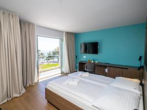 1 dormitorio con cama grande y ventana grande en Hotel Villa Rosetta, en Umag