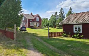 a red house and a house with a fence at Gorgeous Home In Venjan With House A Panoramic View in Västbygge