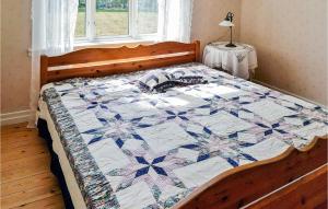 a bed with a quilt on it in a bedroom at Gorgeous Home In Venjan With House A Panoramic View in Västbygge
