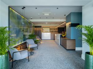 an office lobby with chairs and plants at Hotel Villa Rosetta in Umag