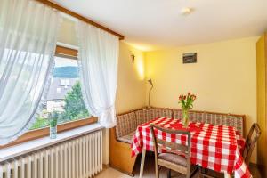 uma mesa de jantar com uma toalha de mesa xadrez vermelha e branca em Bergblick em Forbach