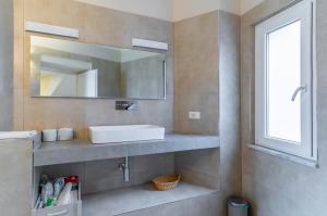 ein Bad mit einem Waschbecken und einem Spiegel in der Unterkunft Comfy & Roomy Apt - View on the Ligurian Hills! in Vezzano Ligure
