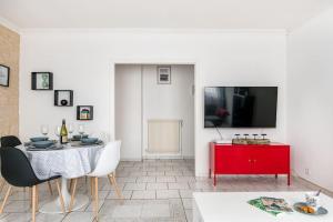 ein Wohnzimmer mit einem Tisch und einem roten Schrank in der Unterkunft Le City Center spacieux et chic in Saint-Étienne