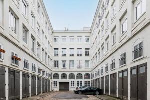 Un coche aparcado en un callejón entre dos edificios. en Le City Center spacieux et chic, en Saint-Étienne
