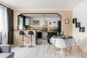eine Küche und ein Wohnzimmer mit einem Tisch und Stühlen in der Unterkunft Le City Center spacieux et chic in Saint-Étienne