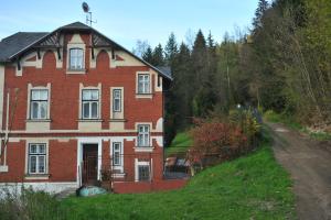 una casa di mattoni rossi su una collina vicino a una strada sterrata di Apartmán Rybná - Kraslice a Kraslice