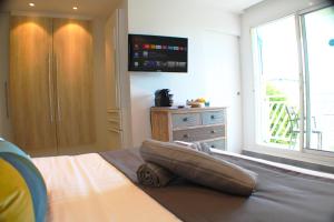 a bedroom with a bed with a tv on the wall at La Casaboubou in Saint-François