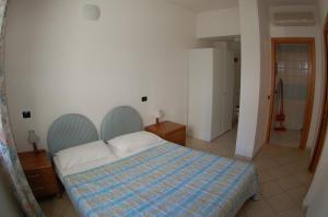 a bedroom with a bed with a blue and white blanket at APPARTAMENTI SIVIGLIA in Cattolica +5 photos