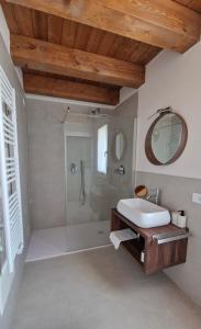 uma casa de banho com um chuveiro, um lavatório e um espelho. em Casa Ossan em San Pietro in Cariano
