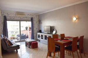een woonkamer met een eettafel en een televisie bij Apartamento Sol Nascente by Portucasa in Albufeira