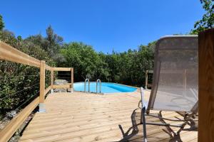 een terras met een zwembad en een stoel ernaast bij Le Mas des Rouquets - avec piscine et jardin in Anduze