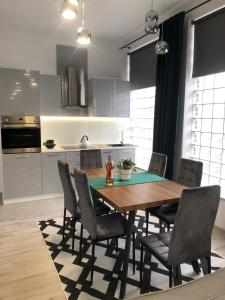 a kitchen with a wooden table and chairs at Apartamenty MAX blisko Energylandia in Ryczów