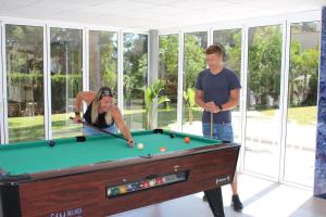 a man and a woman playing a game of pool at Bluewater Hotel in Colònia de Sant Jordi