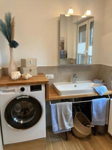 a bathroom with a washing machine and a sink at Ferienwohnungen auf dem Erlenhof in Beverungen