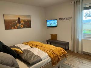 a bedroom with a bed and a tv on the wall at Ferienwohnungen auf dem Erlenhof in Beverungen
