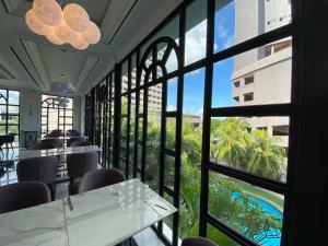 a restaurant with a view of the pool through windows at Grand Eska Hotel & Suites Batam in Nagoya