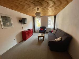 uma sala de estar com um sofá e duas cadeiras em "Altes Haus" am Kurpark in den Bergen em Zorge
