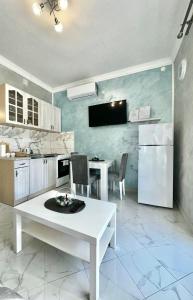 a kitchen with a white table and chairs in it at Albomi in Kotor