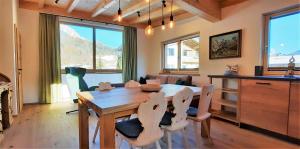 a kitchen and dining room with a wooden table and chairs at vomLandl Natur Lofts & Apartments Leogang in Leogang