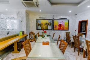 河內的住宿－A25 Hotel - 221 Bạch Mai，一间带长桌和椅子的用餐室