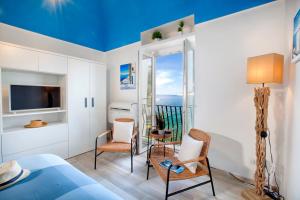 - une chambre avec un lit, des chaises et un balcon dans l'établissement Estate4home - Blu Dream Massa, à Massa Lubrense