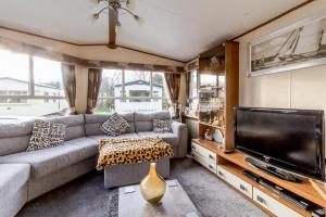 a living room with a couch and a flat screen tv at Lovely Caravan For Hire With Decking At Skipsea Sands In Yorkshire Ref 41015wf in Barmston