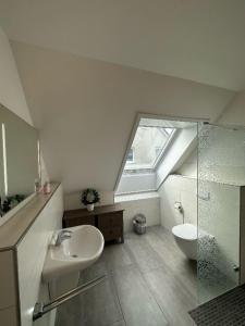 een badkamer met een wastafel, een toilet en een raam bij Nini in Burg auf Fehmarn