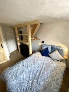 um quarto com uma cama com lençóis azuis e uma escada em Studio duplex en face Les Arcs em Bourg-Saint-Maurice