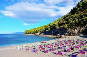 una playa con sillas coloridas y el océano en La casetta a Fiumicello, en Maratea