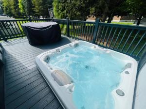 un bain à remous installé au-dessus d'une terrasse dans l'établissement Coopers Corner, Lodge with Hot Tub, à York