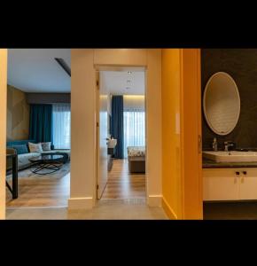 een woonkamer met een wastafel en een spiegel bij Lux Apartment C-LOUNGE CLEOPATRA, Cleopatra beach Alanya in Alanya