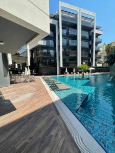 a swimming pool in front of a building at Lux Apartment C-LOUNGE CLEOPATRA, Cleopatra beach Alanya in Alanya