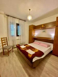 a bedroom with a large bed and a chair at Apartman Mira in Opatija