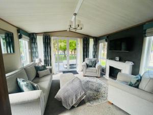 un salon avec un canapé et une cheminée dans l'établissement Coopers Corner, Lodge with Hot Tub, à York