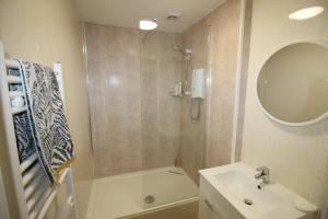 a bathroom with a shower and a sink and a mirror at The Bungalow in Lytham St Annes
