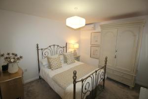 1 dormitorio con cama y lámpara de araña en The Bungalow en Lytham St Annes
