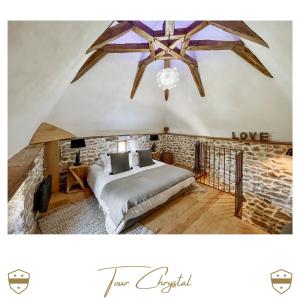 1 dormitorio con cama y pared de ladrillo en Château de Laforest - Les Tours, en Thizy-les-Bourgs