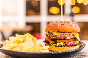 une assiette avec un hamburger et des frites sur une table dans l'établissement Hotel ibis Porto Gaia, à Vila Nova de Gaia