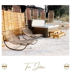 un patio con bañera, 2 sillas y un banco en Château de Laforest - Les Tours, en Thizy-les-Bourgs