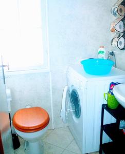 a bathroom with a washing machine with a toilet and a sink at ARThouse ANNA Villa in Lignano Sabbiadoro