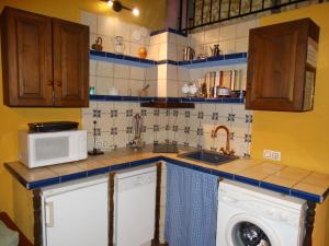 a kitchen with a sink and a washing machine at Casa La Cantonera con zona relax jacuzzi in La Cuba