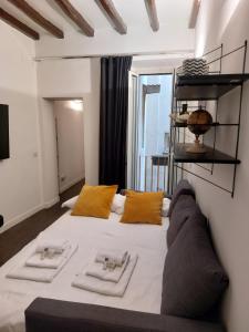 a bedroom with a large white bed with yellow pillows at EasyInRome Navona in Rome